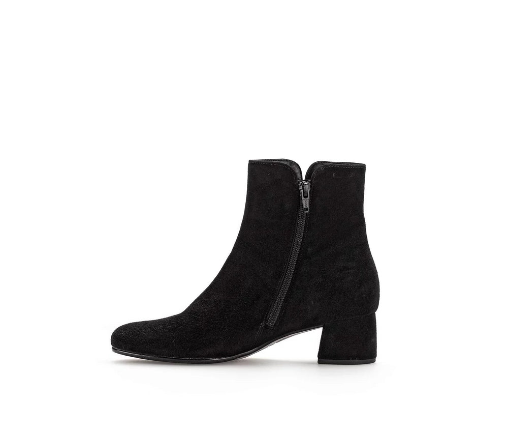 Black suede ankle boots with a zipper on a white background