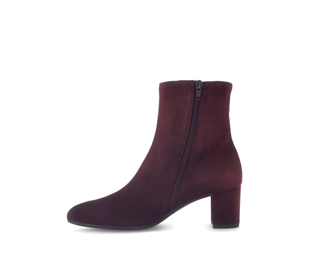 Burgundy ankle boot with a zipper on a white background