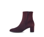 Burgundy ankle boot with a zipper on a white background